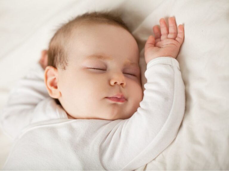 bébé dort les bras en l'air